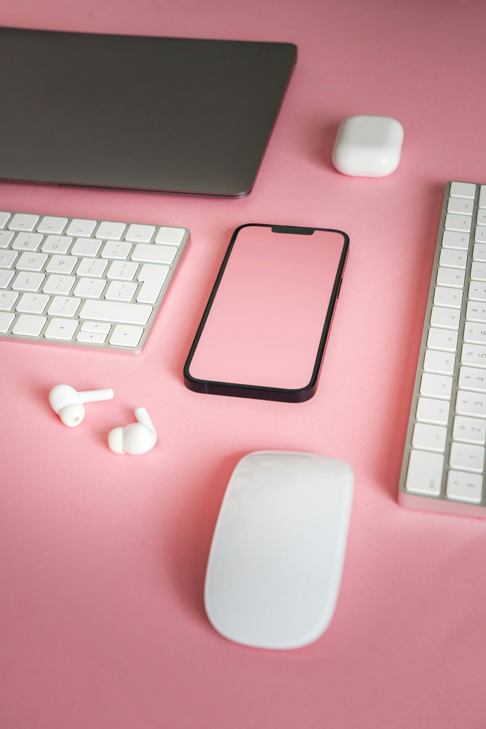 a pink desk with a keyboard, mouse, and a phone